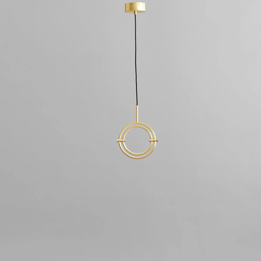 Brass pendant light fixture on a gray background