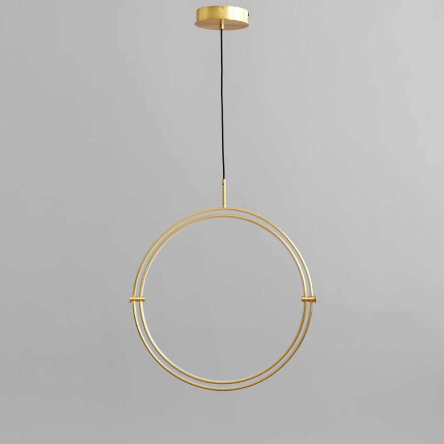 Brass circular pendant light on a gray background