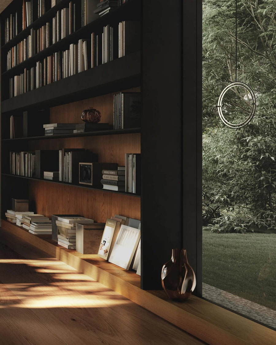 Bookshelf with books and decor next to a window with a view of greenery