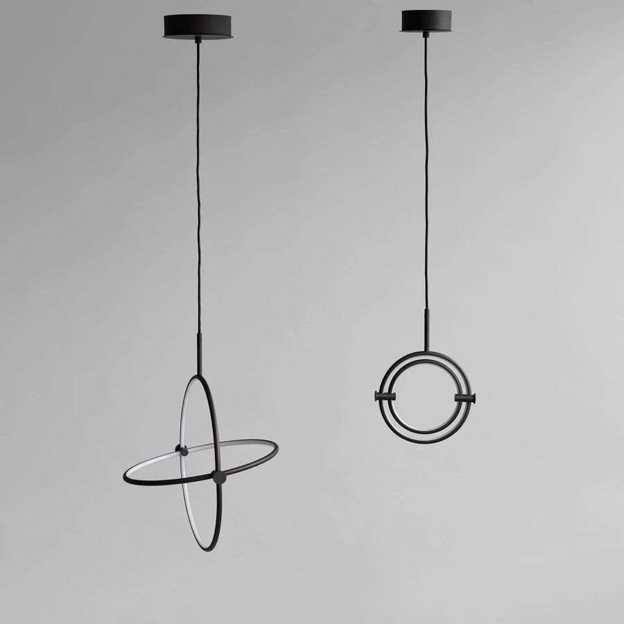 Two modern pendant lights with circular designs on a gray background