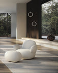 Modern white chair and ottoman in a Japandi theme room with large windows and natural light