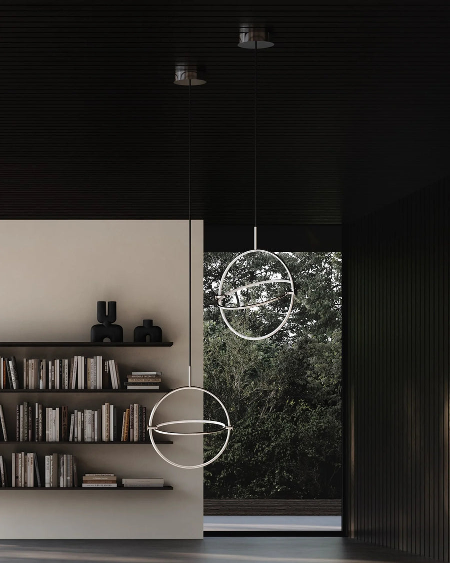 Modern interior with circular pendant lights and a bookshelf.