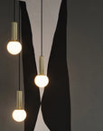 Three hanging light bulbs with brass fixtures against a dark background