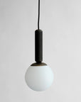 Minimal Scandinavian design white pendant light with black fixture on a plain background