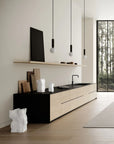 Modern kitchen with black and white cabinetry, wooden flooring, and a large window.