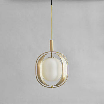 Modern pendant light with brass fixture and white glass shade on a gray background