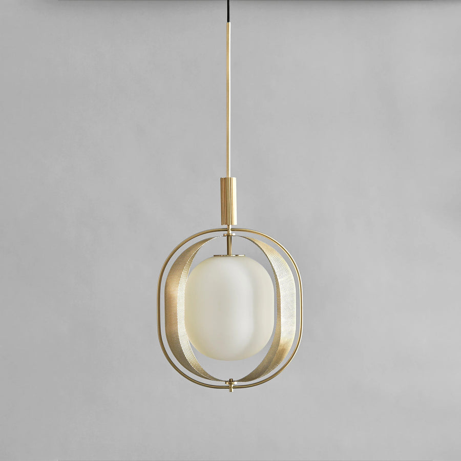 Modern pendant light with brass fixture and white glass shade on a gray background