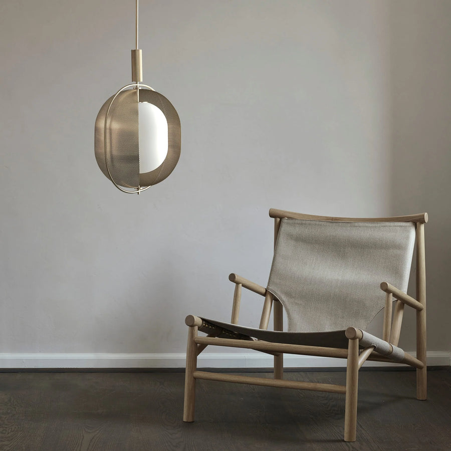 Modern Scandinavian chair with a hanging lamp against a plain wall