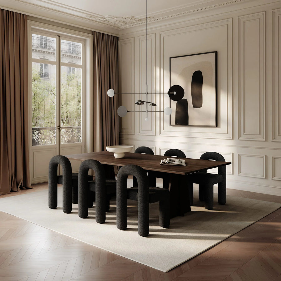 Modern dining room with a wooden table and black chairs in a stylishly decorated room.