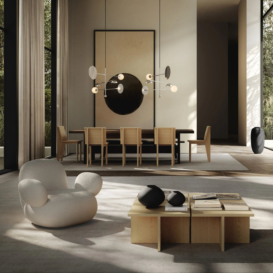 Modern living room with a white armchair, wooden coffee table, and dining area.