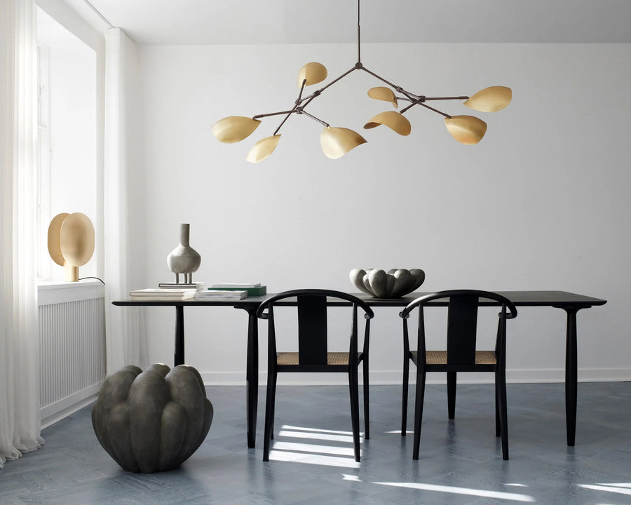 Modern dining room with black table and chairs, decorative vases, and a chandelier.