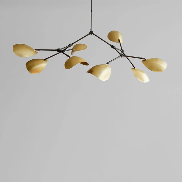 Modern chandelier in brass finish on a gray background from 101 Copenhagen available at Spacio retail stores in Mumbai & Kolkata. 