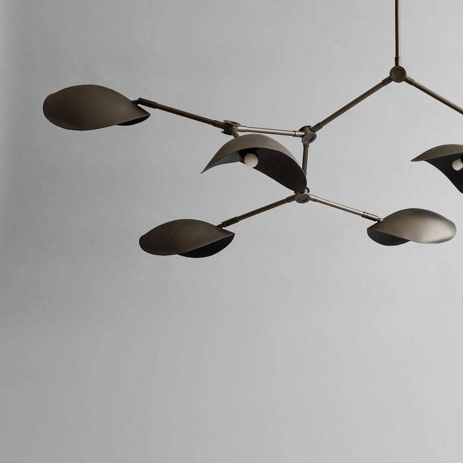 Modern chandelier with multiple lampshades on a plain background