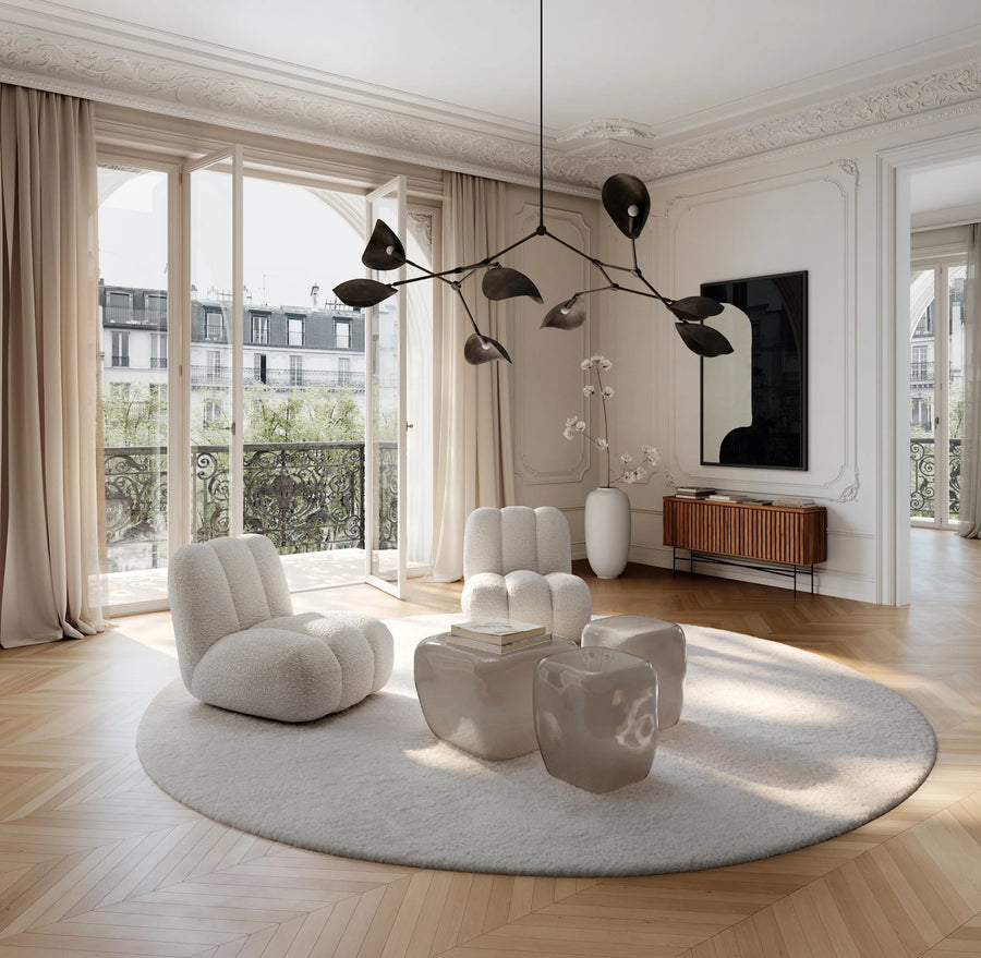Modern living room with white furniture, round rug, and large windows.