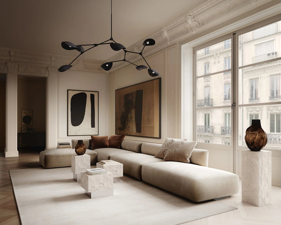 Modern living room with a sectional sofa, abstract art, and large windows.