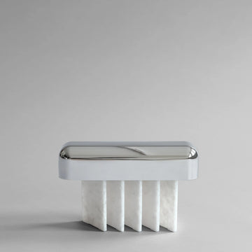 White minimal table lamp with metallic rim on a light gray background