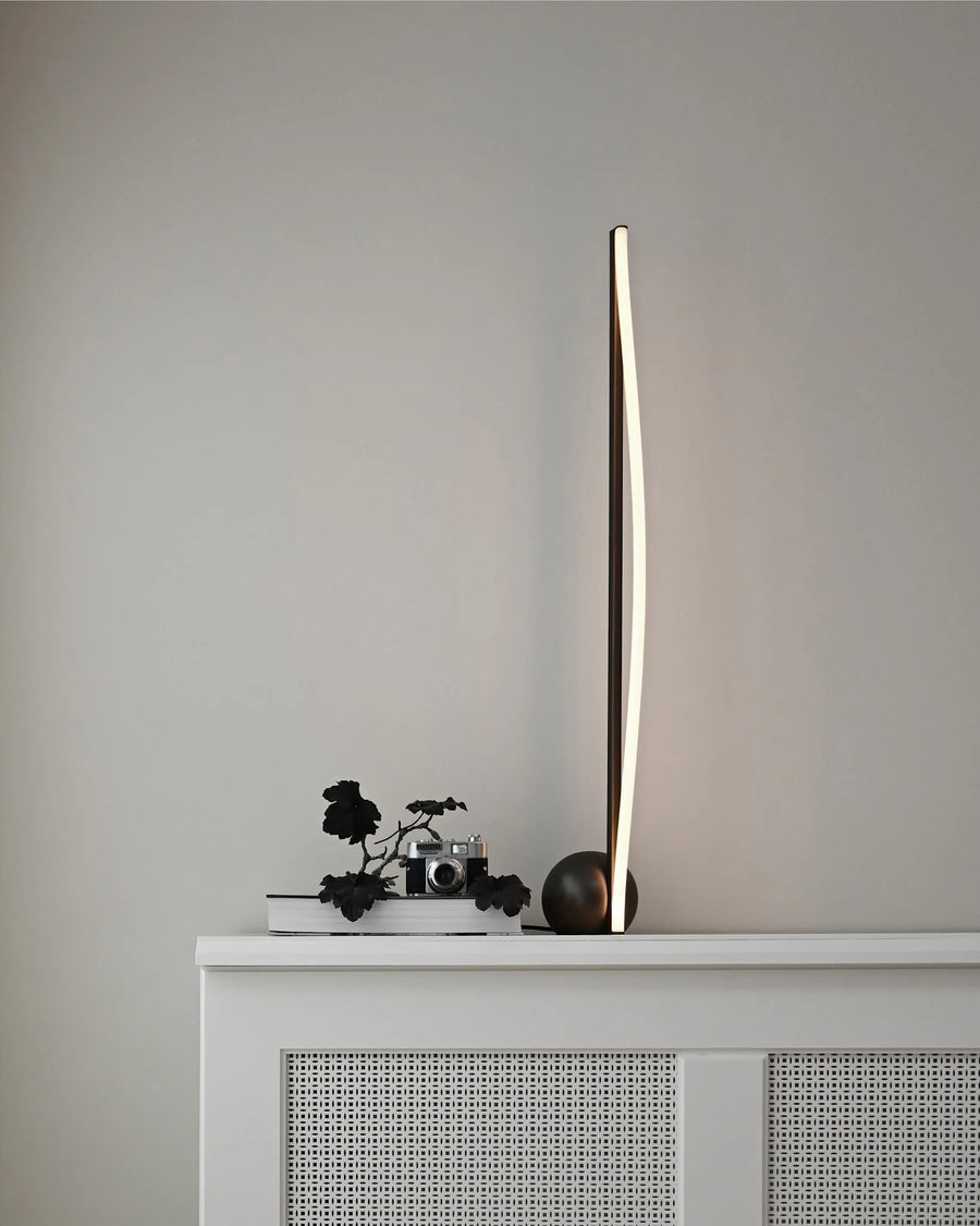 Modern floor lamp on a white cabinet against a gray wall