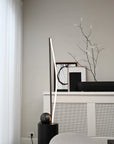 Modern interior design with a black floor lamp and decorative items on a white surface.