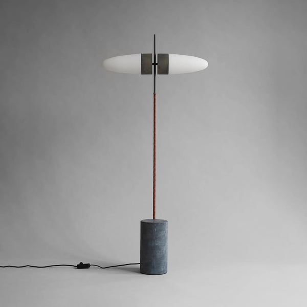 Modern floor lamp with a cylindrical base on a gray background
