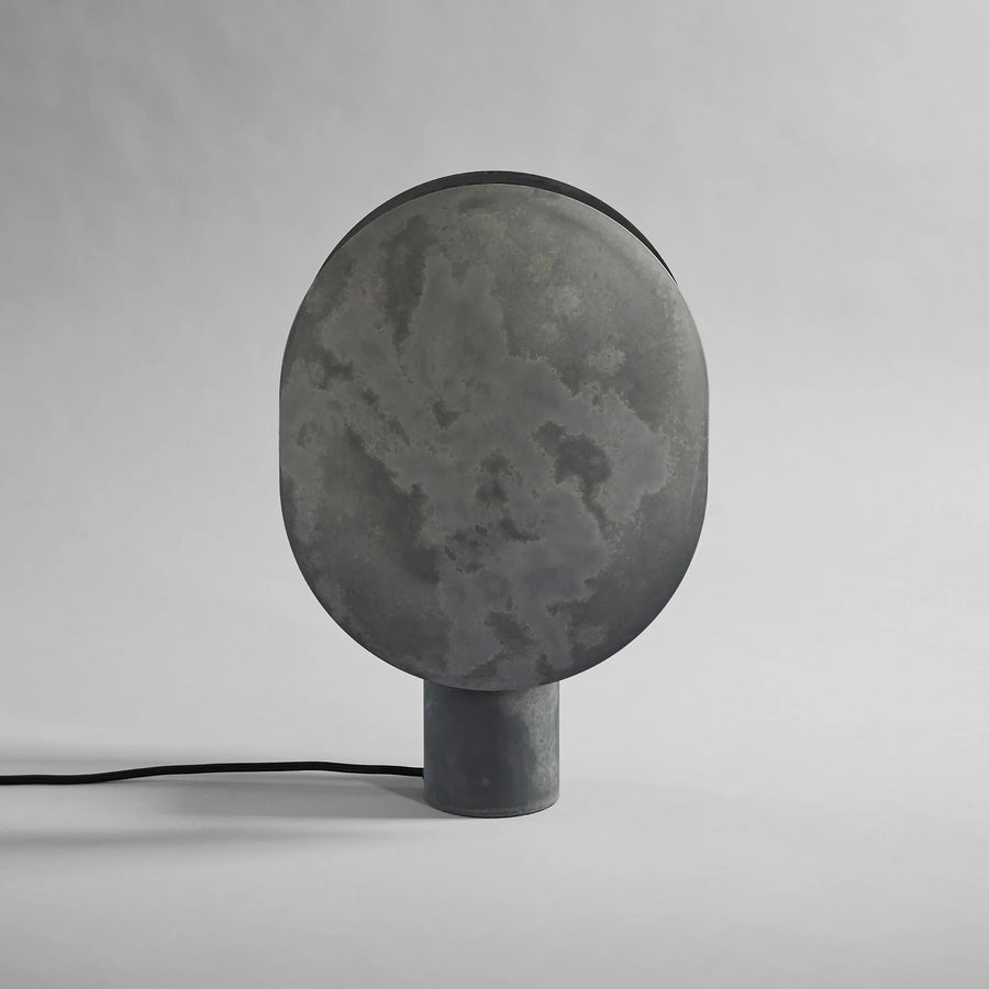 Dark gray concrete lamp on a light gray background from 101 Copenhagen available at Spacio retail stores in Mumbai & Kolkata.