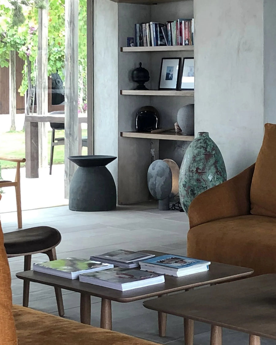Modern living room with a brown sofa, wooden coffee table, and decorative vases.