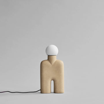 Minimalist lamp with a beige base and white spherical shade on a gray background from 101 Copenhagen available at Spacio retail stores in India. 