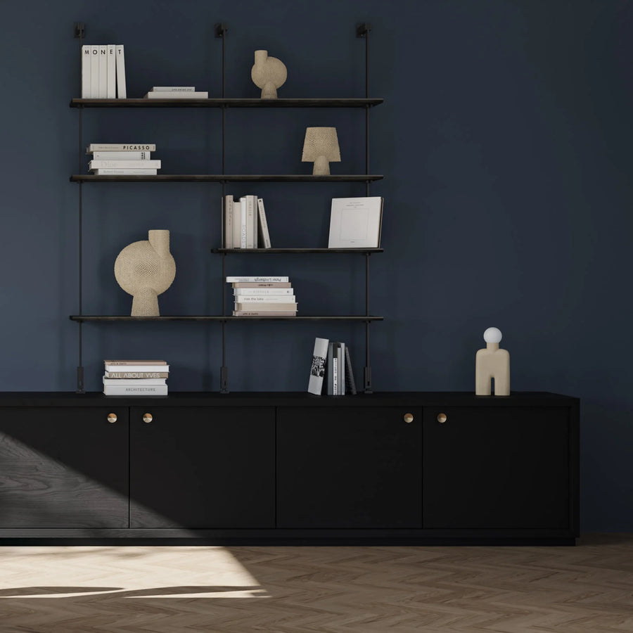 Black shelving unit with decorative items against a dark blue wall