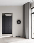 Modern interior with a black wardrobe, mirror, and floor lamp.