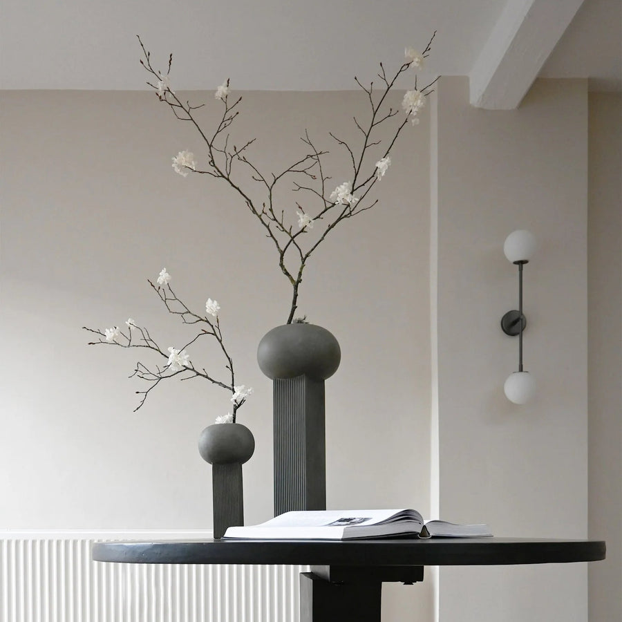 Drop  Wall Light Bulp Grey by 101 Copenhagen along with 2 sculptural vases styled with flowers - available at Spacio retail stores in Mumbai & Kolkata.