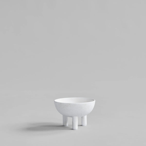 White ceramic bowl on a stand against a light gray background from 101 Copenhagen at Spacio retail stores in Mumbai & Kolkata. 