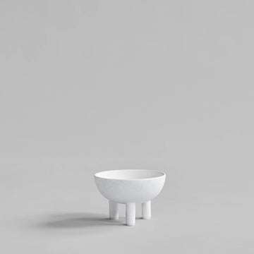 White ceramic bowl on a stand against a light gray background from 101 Copenhagen at Spacio retail stores in Mumbai & Kolkata. 