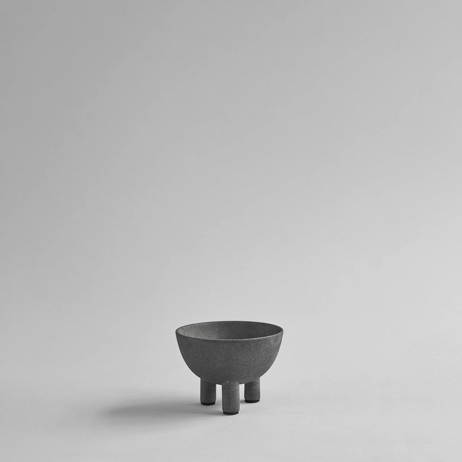 Dark grey ceramic bowl on a light gray background from 101 Copenhagen at Spacio retail stores in Mumbai & Kolkata. 