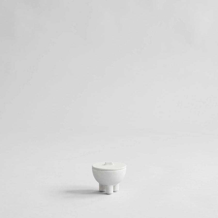 White ceramic bowl with lid on a light gray background from 101 Copenhagen at Spacio retail stores in Mumbai & Kolkata. 