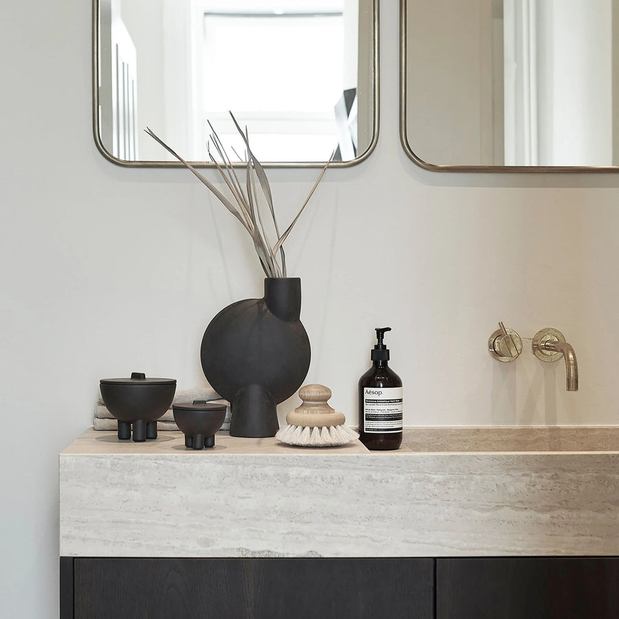 Bathroom vanity with decorative items including a black vase and bottles from 101 Copenhagen at Spacio retail stores in Mumbai & Kolkata. 