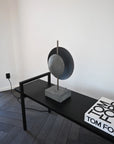 Modern black and gray sculpture on a black platform with 'Tom Ford" coffee table book.