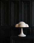 White cloud-shaped lamp on a dark wooden cabinet