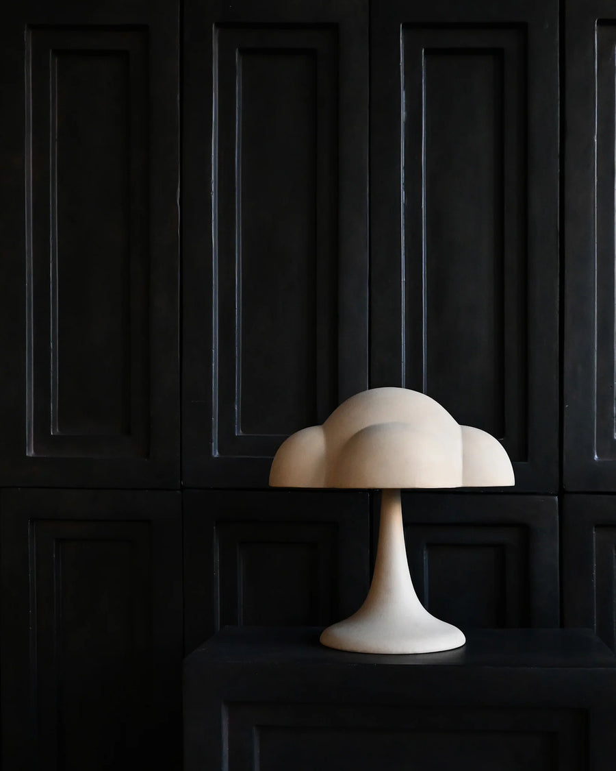White cloud-shaped lamp on a dark wooden cabinet