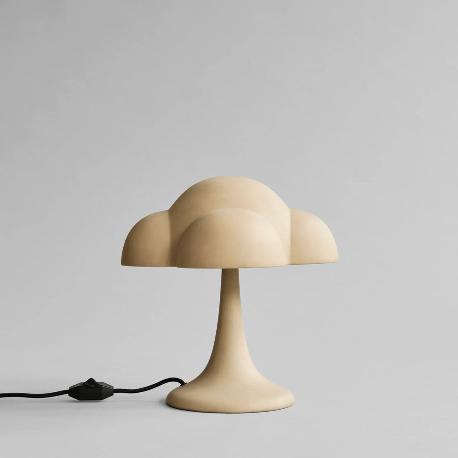 Beige table lamp with a cloud-like design on a gray background from 101 Copenhagen available at Spacio retail stores in Mumbai & Kolkata. 
