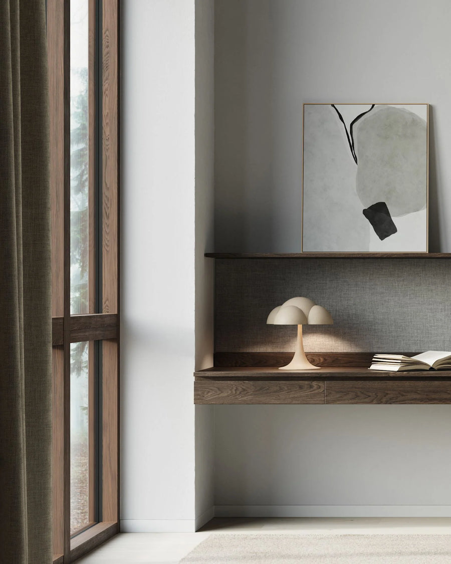 Modern interior with a shelf against a gray wall, featuring a framed abstract painting and decorative items.