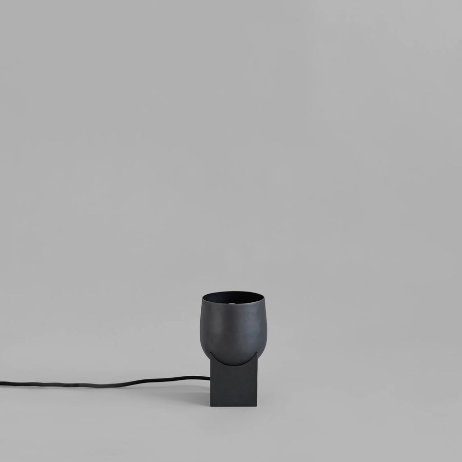 Black lamp with a cylindrical shade on a gray background