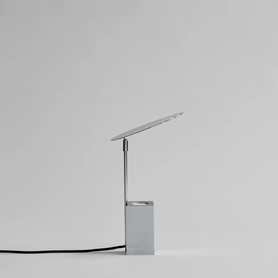 Modern silver desk lamp on a light gray background from 101 Copenhagen available at Spacio retail stores in Mumbai & Kolkata. 