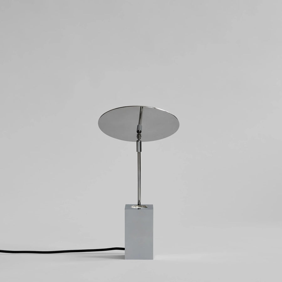 Modern table lamp with round shade and rectangular base on a gray background