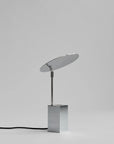Modern table lamp with a reflective shade on a gray background