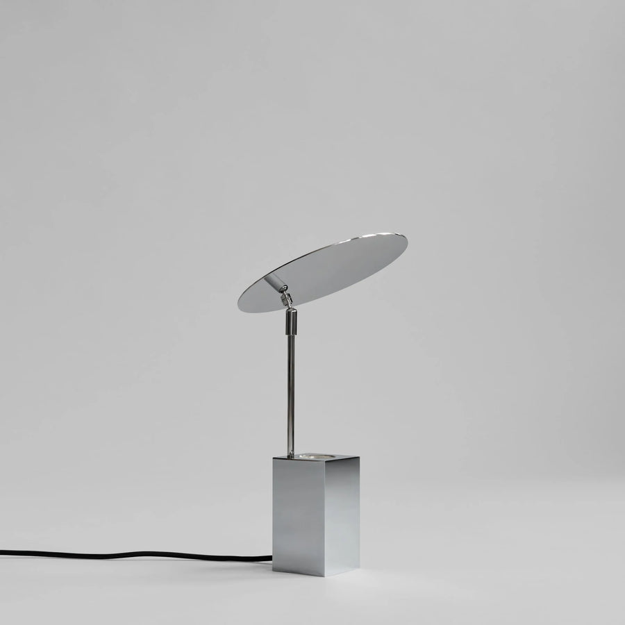 Modern table lamp with a reflective shade on a gray background