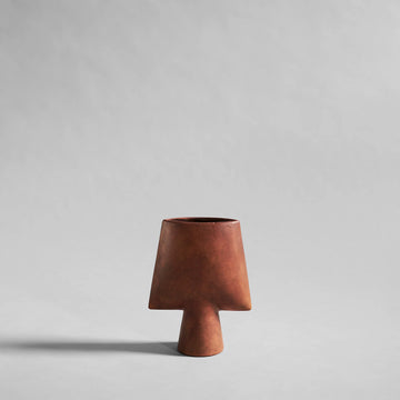 Terracotta colour ceramic vase on a light gray background from 101 Copenhagen available at Spacio retail and online stores in India. 