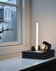 Modern table lamp with a rock-like base on a surface near a window