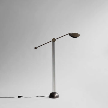 Modern floor lamp with adjustable arm on a gray background from 101 Copenhagen available at Spacio retail stores in Mumbai & Kolkata. 