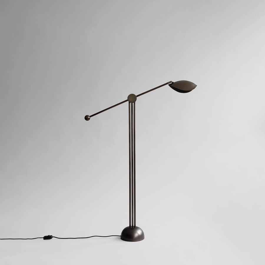 Modern floor lamp with adjustable arm on a gray background from 101 Copenhagen available at Spacio retail stores in Mumbai & Kolkata. 