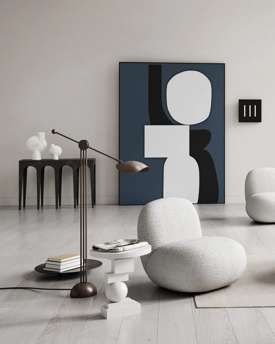 Modern interior with a textured chair, abstract art, and minimal decor.