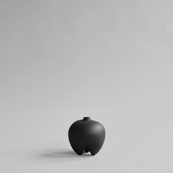Black ceramic vase on a light gray background from 101 Copenhagen at Spacio retail stores in Mumbai & Kolkata. 